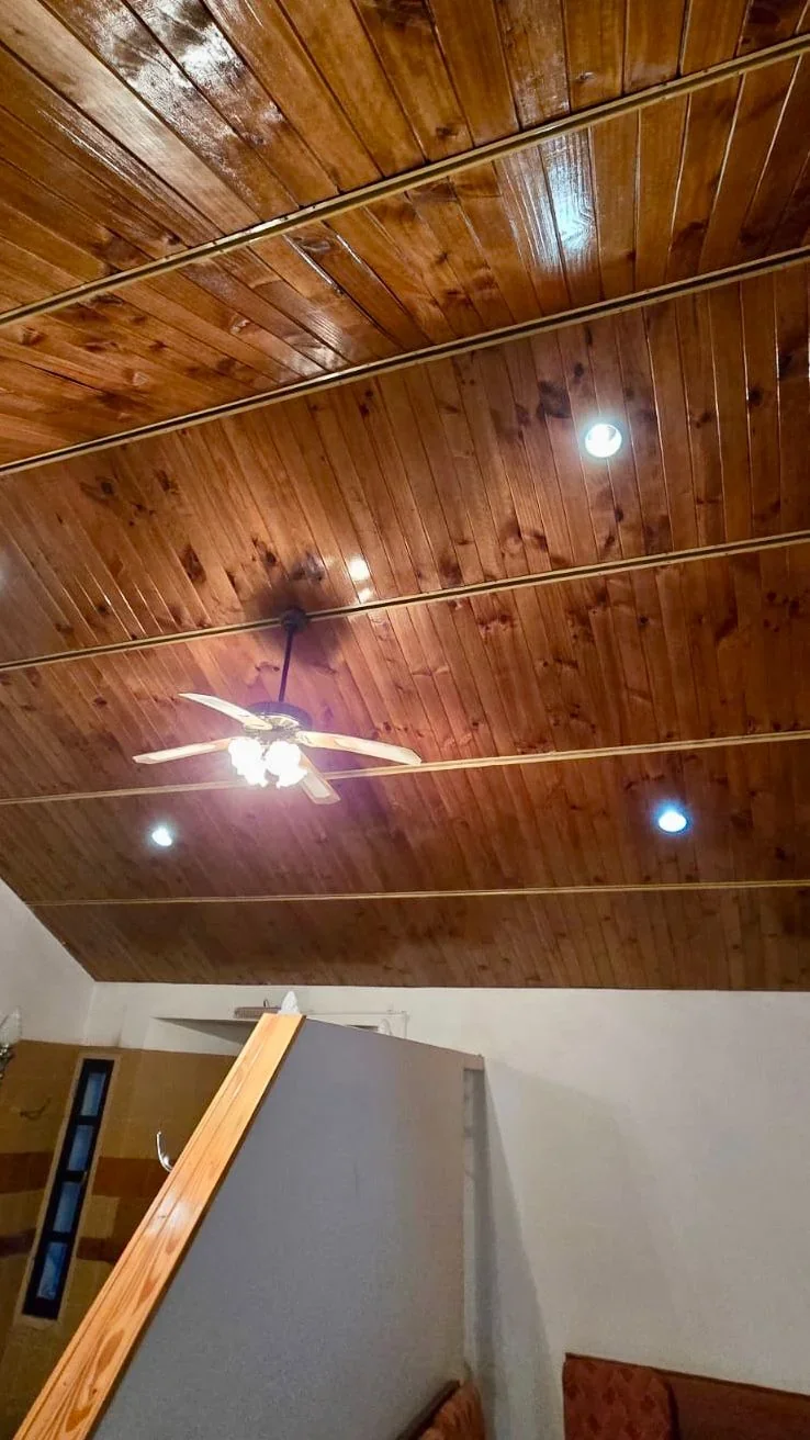 Vista del techo de madera con ventilador y luces en una de las salas del Servicio Solidario de Sepelio en Rawson.