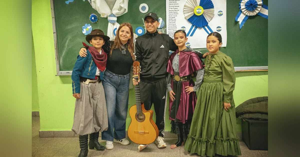 Rawson: Escuela Municipal de Aprendizaje Laboral celebró su 38° aniversario Estudiantes disfrazados y docentes de la Escuela Municipal de Aprendizaje Laboral de Rawson posan con una guitarra.