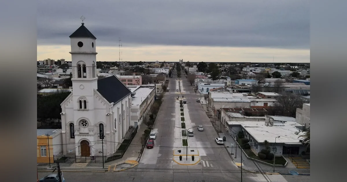 Rawson: Finalizó la primera etapa de la remodelación del bulevar San Martín Vista aérea del bulevar de la avenida San Martín en Rawson, con su nueva pavimentación y una iglesia blanca al costado.