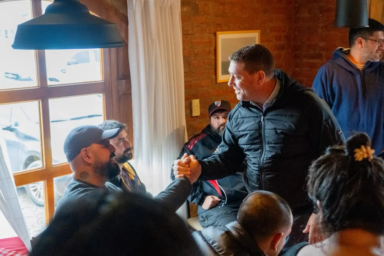 El intendente Damián Biss estrecha la mano de un representante gastronómico durante una reunión en Rawson.