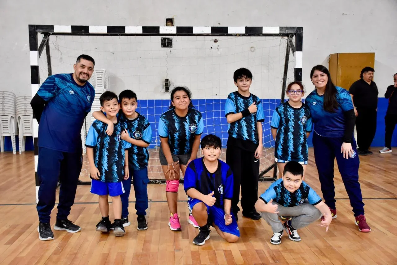 Niños y entrenadores del Taller Municipal de Handball de Trelew posando frente al arco en el Gimnasio Municipal 1.