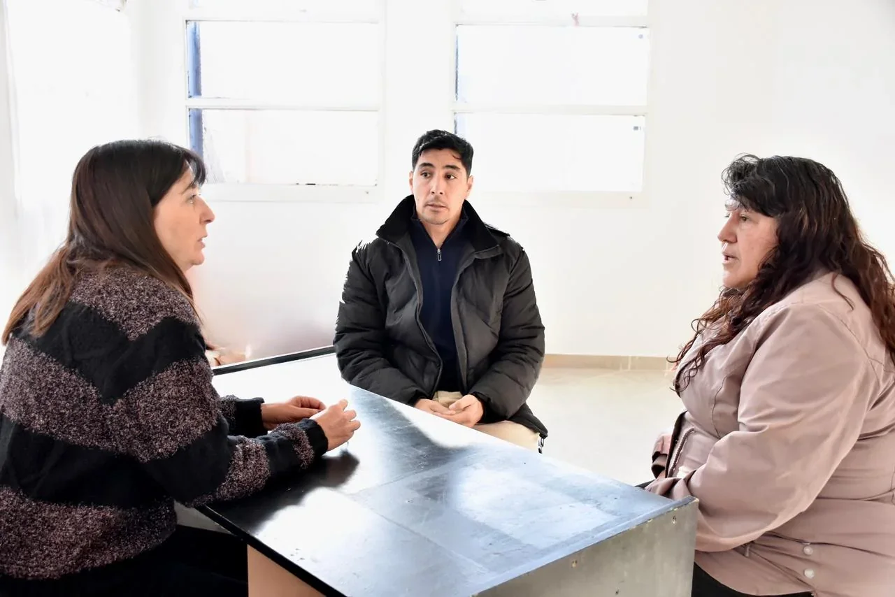 Carola Cordón, un funcionario y Hilda Romero reunidos frente a una mesa en el CPS del barrio INTA de Trelew.