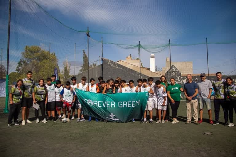 Autoridades municipales, profesores y jóvenes posando con la bandera de Forever Green