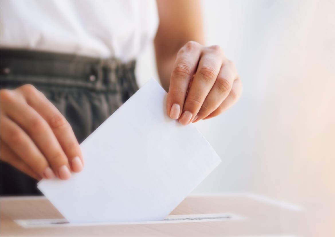 Elecciones vecinales en Puerto Madryn: votarán en Presidente Perón, El Doradillo, Galina, Quintas del Mirador y Perito Moreno Persona depositando un sobre de voto en una urna electoral