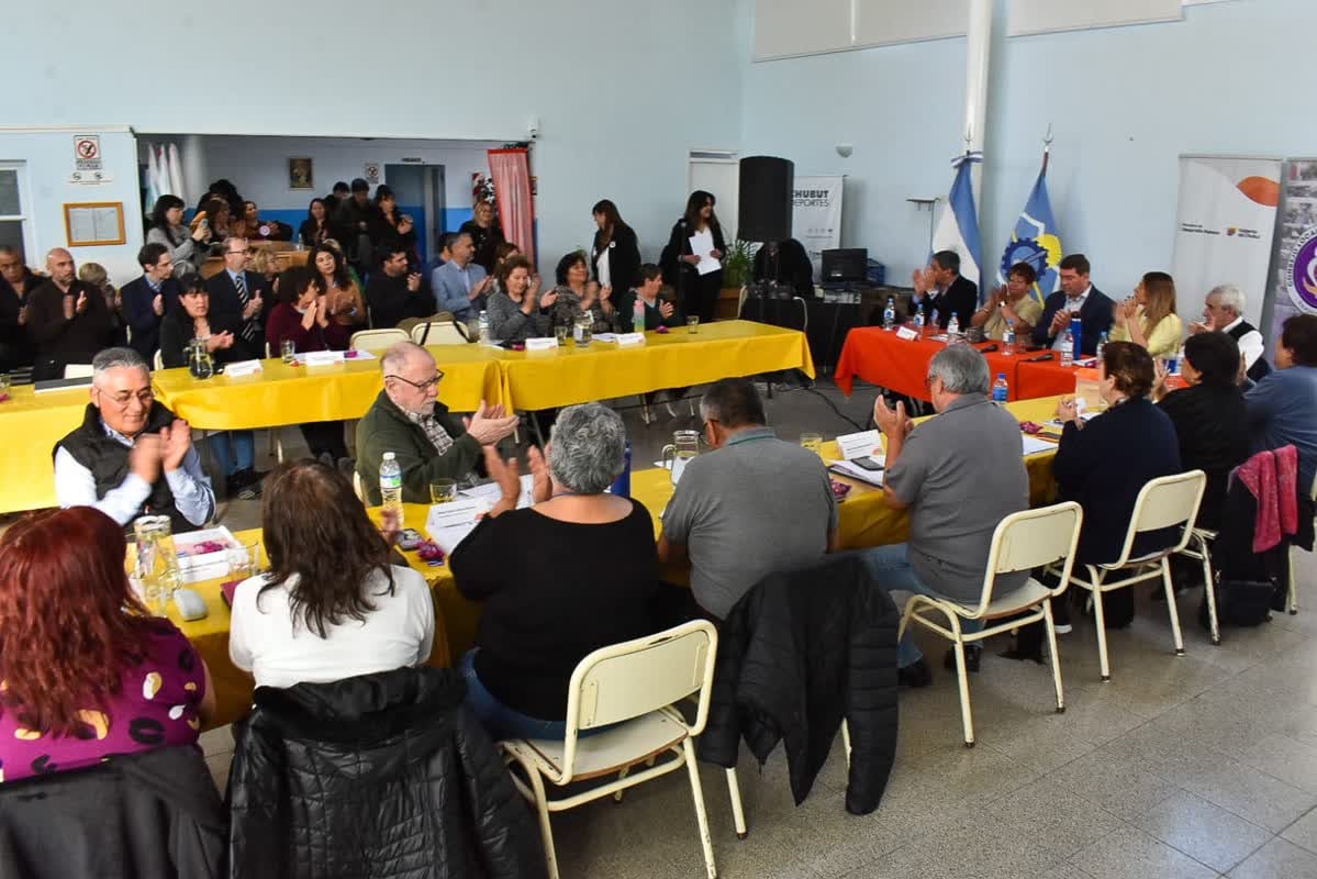 Asistentes y autoridades sentados alrededor de varias mesas
