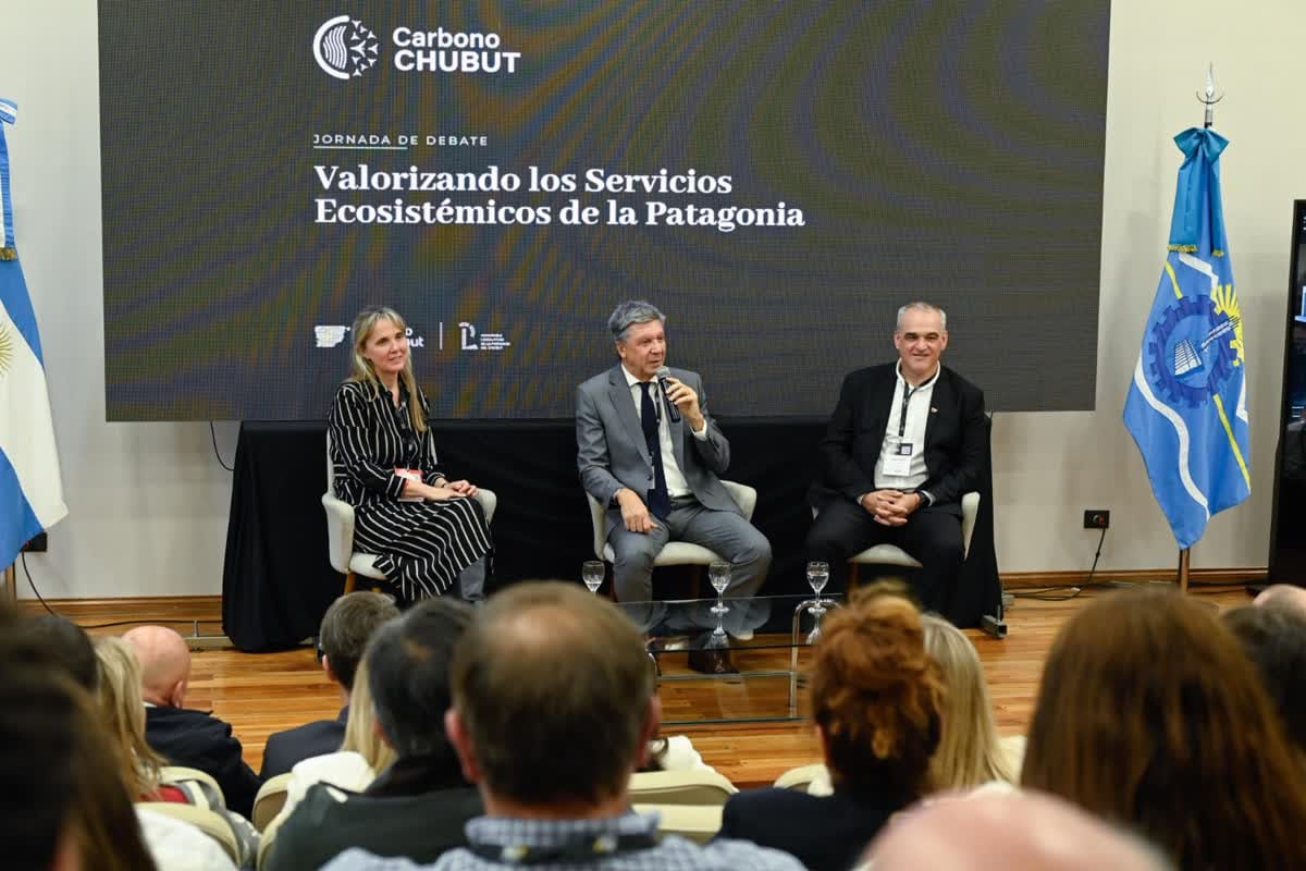 Tres autoridades sobre el escenario en un auditorio